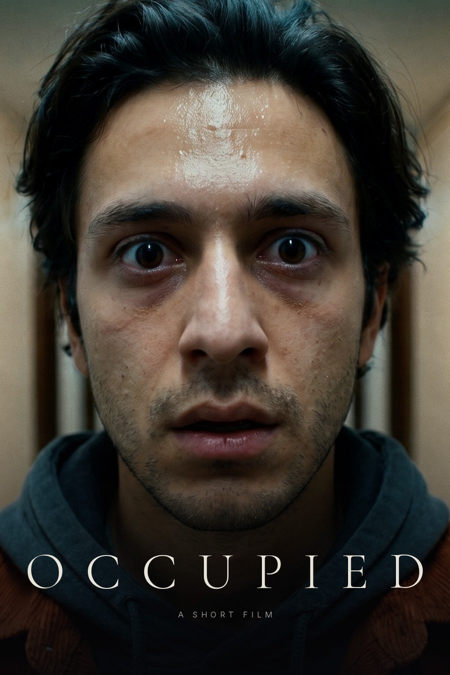 OCCUPIED poster: a tight close-up of Eli, sweating and wide-eyed, with the title in thin serif capitals